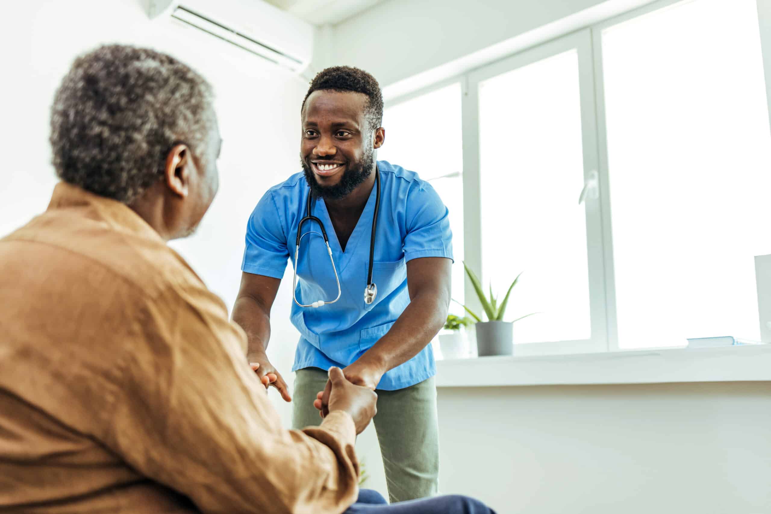 Shot of a nurse holding a senior man's hands in comfort.